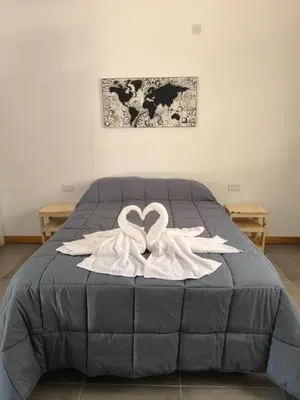 a bed with two white swans forming a heart at AlojaMenta in Nono