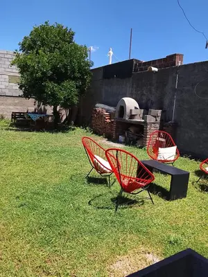 three red chairs and a table in a yard at Majo in San Francisco del Monte de Oro