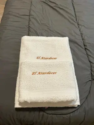 a white towel sitting on top of a bed at El Atardecer in Trapiche