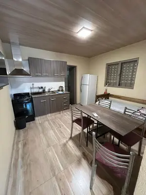 a kitchen with a wooden table and a dining room at El Atardecer in Trapiche