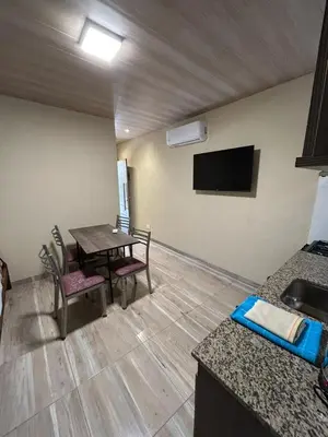 a room with a table and chairs and a television at El Atardecer in Trapiche
