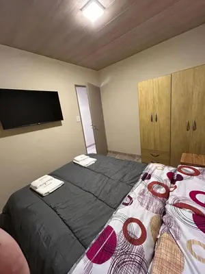a bedroom with two beds and a flat screen tv at El Atardecer in Trapiche