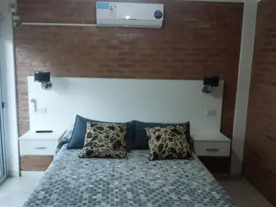 a bedroom with a bed with a brick wall at Gabriel in Mina Clavero