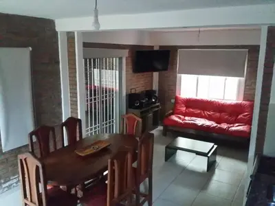a living room with a table and a red couch at Gabriel in Mina Clavero