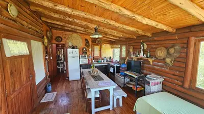 a kitchen in a log cabin with a refrigerator at Cabaña UMI - Un Mundo Infinito in Potrero de Garay