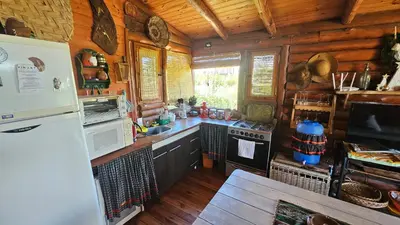 a kitchen in a log cabin with a refrigerator at Cabaña UMI - Un Mundo Infinito in Potrero de Garay
