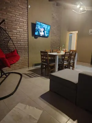 a living room with a table and chairs and a tv at Cabaña Quimey in Villa Rumipal