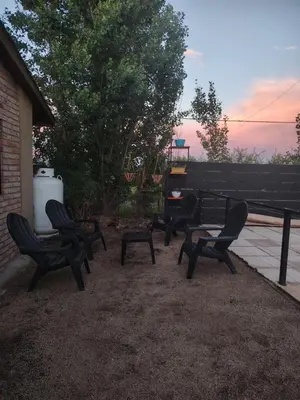 a group of chairs sitting next to a bench at Cabaña Quimey in Villa Rumipal