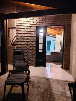 a chair in front of a room with a living room at Cabaña Quimey in Villa Rumipal