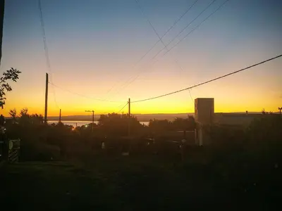 a sunset with the sun setting in the background at Cabaña Quimey in Villa Rumipal