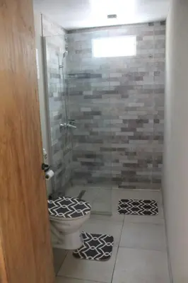 a bathroom with a toilet and a glass shower at Mirabela Casa con vista panorámica a las sierras en Bialet Massé- Hasta 4 personas in Bialet Massé