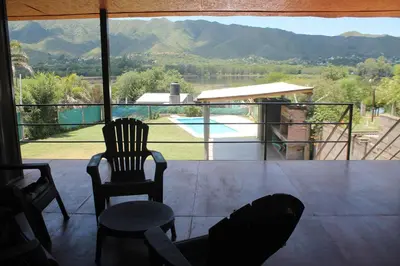 a balcony with two chairs and a view of a pool at Mirabela Casa con vista panorámica a las sierras en Bialet Massé- Hasta 4 personas in Bialet Massé
