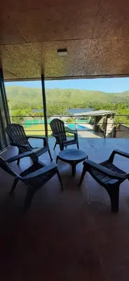 two chairs and a table in a room with a pool at Mirabela Casa con vista panorámica a las sierras en Bialet Massé- Hasta 4 personas in Bialet Massé