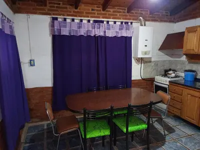 a kitchen with a table and chairs in a kitchen at Mi Niña's in Villa Cura Brochero