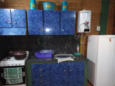 a blue kitchen with a sink and a refrigerator at Mi Niña's in Villa Cura Brochero