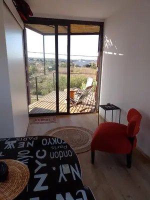 a room with a view of a deck with a bed and a chair at Containers UMI - Un Mundo Infinito in Potrero de Garay