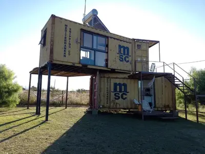 a house is being built in the grass at Containers UMI - Un Mundo Infinito in Potrero de Garay
