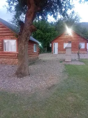 a house with a tree next to a building at Posta Nativa in Santa Rosa de Calamuchita