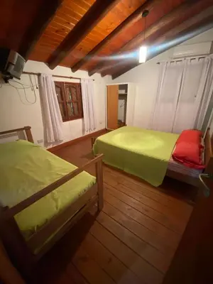 two beds in a room with wooden floors at Abuelo Ramón in Mina Clavero