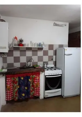 a kitchen with a stove and a refrigerator at Abuelo Ramón in Mina Clavero