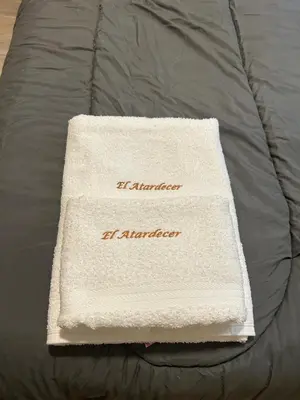 a white towel sitting on top of a bed at El Atardecer in Trapiche