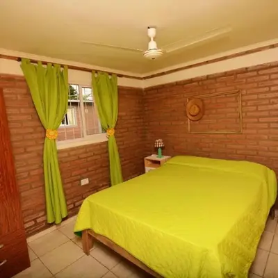 a bedroom with a yellow bed and a window at Complejo cerca del rio in Villa Carlos Paz