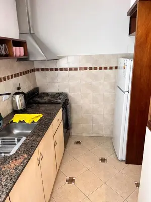 a small kitchen with a stove and a refrigerator at Departamento moderno para 3 personas en Zona Nueva Córdoba in Cordoba