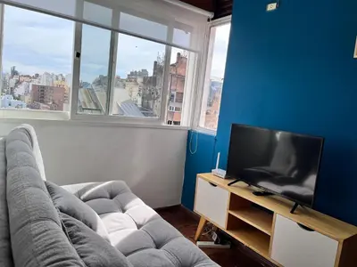a living room with a couch and a flat screen tv at Departamento moderno para 3 personas en Zona Nueva Córdoba in Cordoba