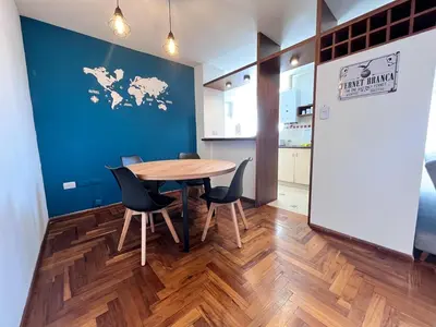 a table and chairs in a room with a blue wall at Departamento moderno para 3 personas en Zona Nueva Córdoba in Cordoba
