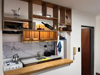 a kitchen with wooden cabinets and a sink at Departamento para 4 personas Zona cercana al Centro in Cordoba