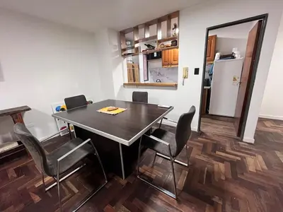 a dining room with a table and chairs and a kitchen at Departamento para 4 personas Zona cercana al Centro in Cordoba