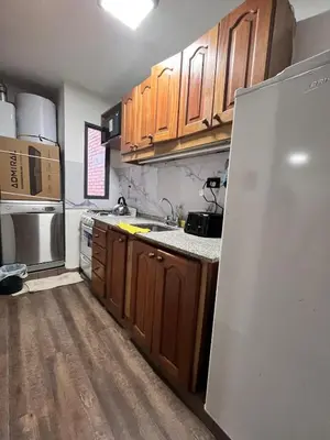 a kitchen with wooden cabinets and a white refrigerator at Departamento para 4 personas Zona cercana al Centro in Cordoba