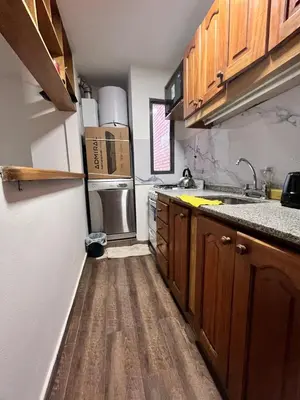 a small kitchen with wooden cabinets and a refrigerator at Departamento para 4 personas Zona cercana al Centro in Cordoba