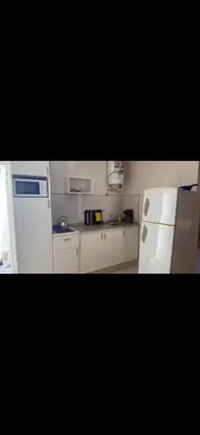 a kitchen with white appliances and a white refrigerator at Departamento monoambiente in Villa Carlos Paz