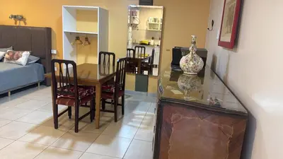 a dining room and living room with a table and chairs at Departamento monoambiente in Villa Carlos Paz