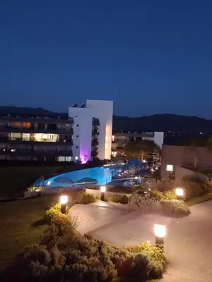 a large building with a swimming pool at night at Veneto Village in Villa Parque Siquiman