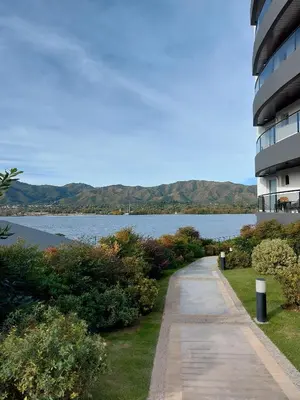 a walkway next to a building next to a lake at Veneto Village in Villa Parque Siquiman
