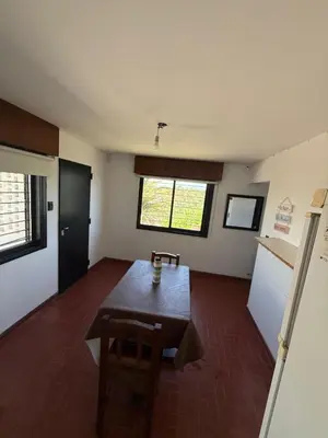an empty room with a table and a refrigerator at Departamento El Fantasio in Villa Carlos Paz
