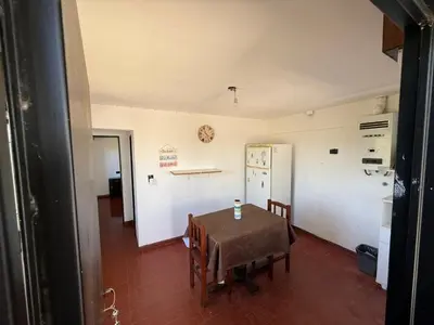 a dining room with a table and a kitchen at Departamento El Fantasio in Villa Carlos Paz