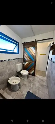 a bathroom with two toilets in a room with a window at El Nogal ll in Villa Carlos Paz