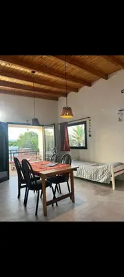 a dining room with a table and chairs and a bed at El Nogal ll in Villa Carlos Paz