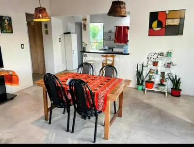 a dining room table with chairs and a kitchen at El Nogal ll in Villa Carlos Paz