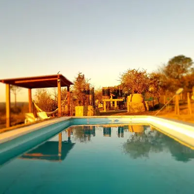 a swimming pool with blue water in front of a house at Mirador Oeste Potrero de Garay in Potrero de Garay