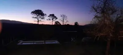 a sunset in a yard with trees in the background at Mirador Oeste Potrero de Garay in Potrero de Garay