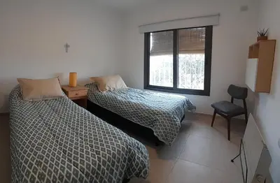 a bedroom with two beds and a window at Mirador Oeste Potrero de Garay in Potrero de Garay