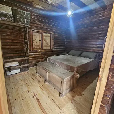 a bedroom with a bed in a wooden cabin at Espacio Yacanto - Cabaña 1 in Villa Yacanto