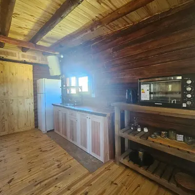 a kitchen with wooden walls and a refrigerator at Espacio Yacanto - Cabaña 1 in Villa Yacanto