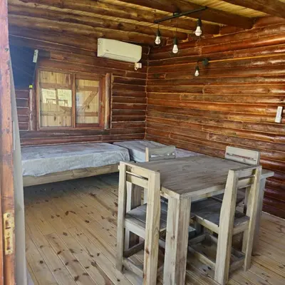 a room with a table and chairs in a log cabin at Espacio Yacanto - Cabaña 1 in Villa Yacanto