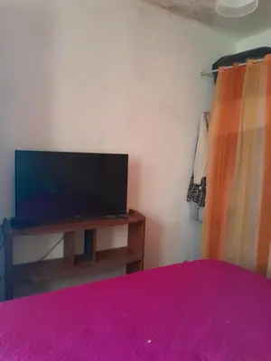 a bedroom with a flat screen tv on a table at 'Ña Emma in Cosquín