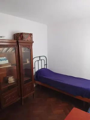 a bedroom with a bed and a wooden cabinet at Casita in Cordoba